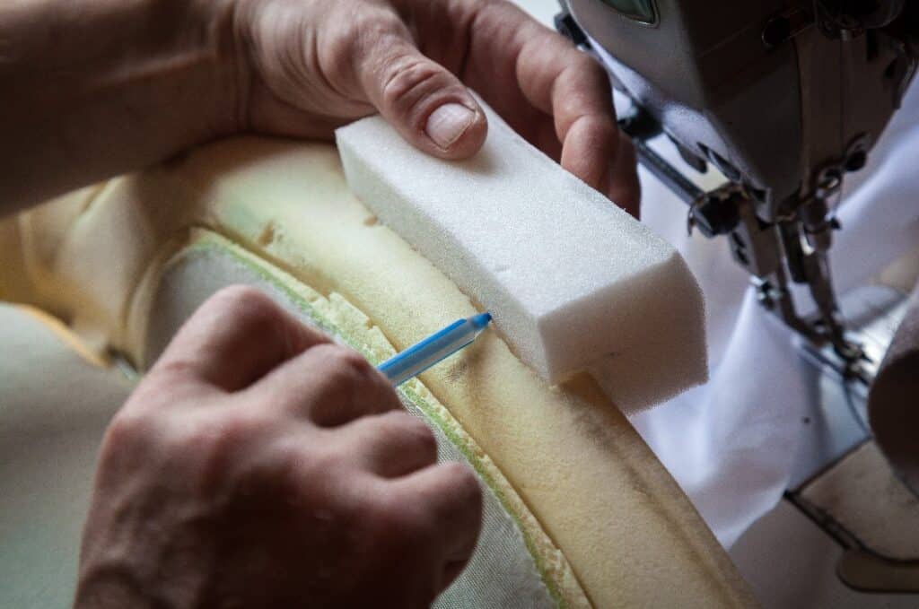 A person repairs the foam seat of a car.